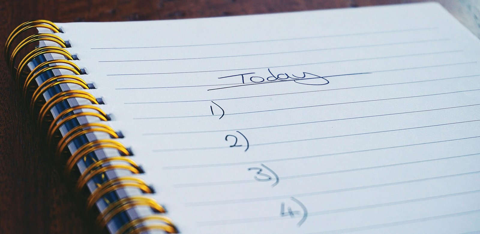 A close-up view of a handwritten to-do list on a spiral notebook with numbers for tasks.
