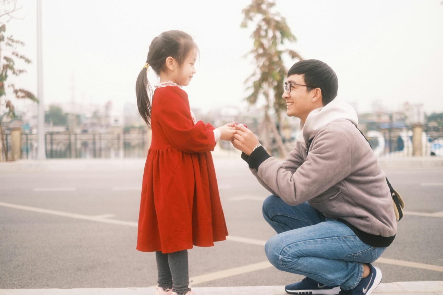 Smiling parent kneeling at child’s level,