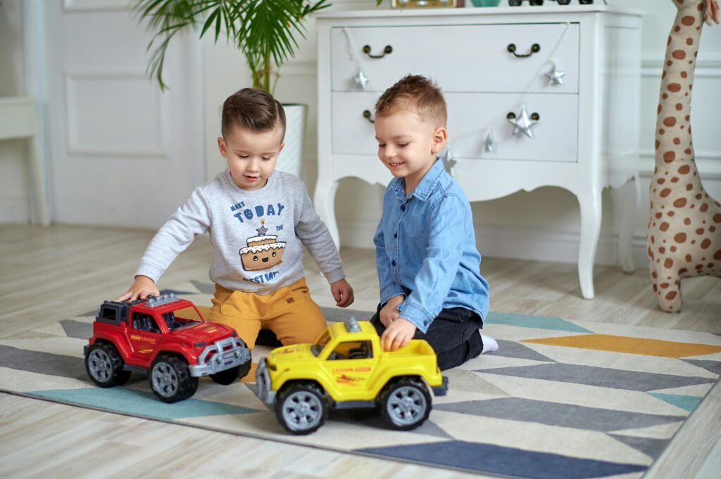 Two young boys enjoy playing with toy cars in a bright, cozy room.